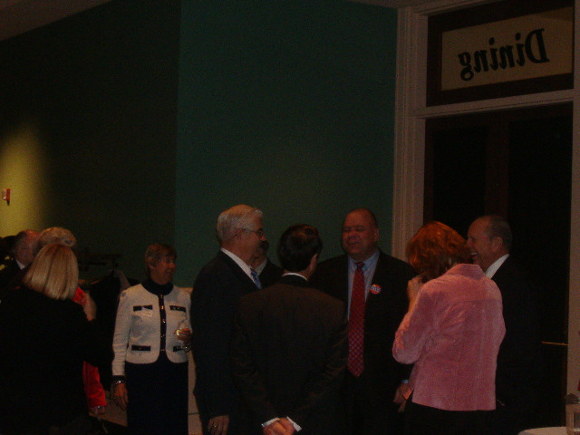 State Senator E.J. Pipkin (center, with red button) was the first to arrive at the ceremony. Here he chats up some of those at the entrance.